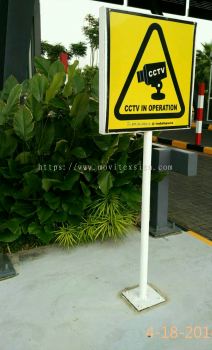 Papan tanda dengan tiang untuk Tanda amaran CCTV yang menunjukkan barang berharga Anda di atas kawalan keselamatan.